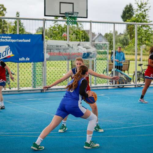 2 Basketballerinnen stehen sich im Dribbling gegenüber.
